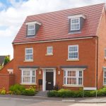 Modern red-brick house with white windows.