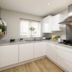 Modern kitchen with white cabinets and appliances.
