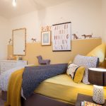 Kid's bedroom with yellow and dog-themed decor.