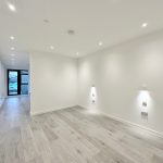 Modern empty room with wooden floor and spotlights.