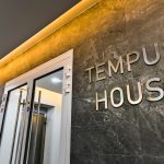 Tempus House entrance signage on marble wall.