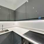 Modern kitchen with grey cabinets and induction hob.