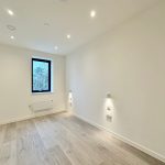 Empty, modern room with light wood flooring.