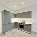 Modern kitchen with grey cabinets and oven.