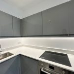 Modern kitchen with grey cabinets and electric hob.