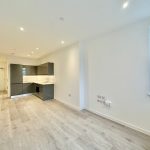 Modern studio flat with kitchen and wood flooring.