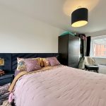 Cosy bedroom with modern decor and large window view.