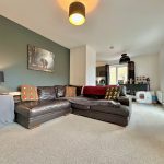 Modern living room with dark sofa and decorative cushions.
