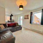 Cosy living room with corner sofa and windows.