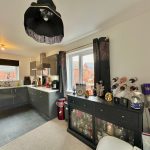 Modern kitchen with dark cabinets and appliances.