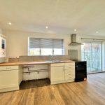 Spacious modern kitchen with wooden flooring.