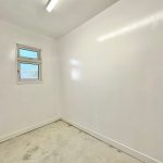 Empty small white room with window and light.