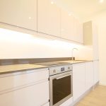 Modern kitchen design with oven and white cabinets.