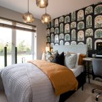 Modern bedroom with patterned wall and cosy bedding.