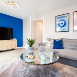Modern living room with blue accent wall and decor.