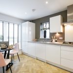 Modern kitchen with dining table and white cabinets.