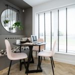 Modern dining area with round table and chairs.