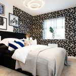 Modern bedroom with patterned wallpaper and decorative lamps.