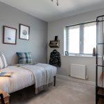 Modern grey bedroom with single bed and decor.