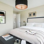 Modern, cosy bedroom with beige décor and soft lighting.