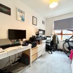 Home office with desks, computers, and exercise bike.