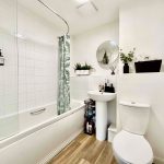 Modern bathroom with green accents and wooden floor