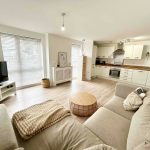 Modern open-plan living room and kitchen with natural light.