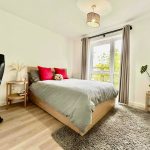 Bright bedroom with modern decor and large window.