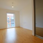 Modern empty room with wooden floor and window.