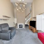 Modern living room with fireplace and grey furniture.