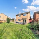 Spacious garden with patio behind brick house
