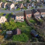 Aerial view of suburban UK houses and gardens.