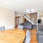 Living room with stairs and wooden dining table.