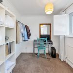 Compact home office with desk and shelving.