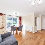 Spacious living room with hardwood flooring and garden view.