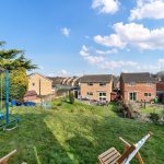 Sunny garden view with houses and swing set