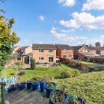 Back gardens and houses with blue sky.