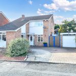 Detached brick house with garden, blue gates.