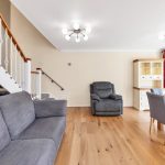 Modern living room with grey sofas and wooden flooring.
