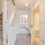 Modern hallway with carpeted stairs and bedroom view
