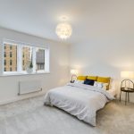 Modern bedroom with double bed and lamps.