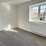 Empty room with carpet and large window.