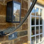 Close-up of a wall lamp and house number eight.