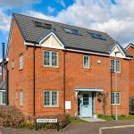New brick house on Ambridge Lane, sunny day.