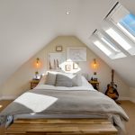 Cosy bedroom with skylights and guitar on display.