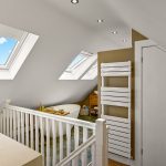 Modern attic bathroom with skylights and freestanding bath.
