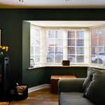 Bright living room with bay window and yellow flowers.