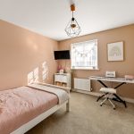 Cosy bedroom with keyboard and pink bedding.