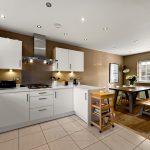 Modern kitchen with dining area and wooden table.
