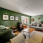 Modern lounge with green walls and cosy sofas.